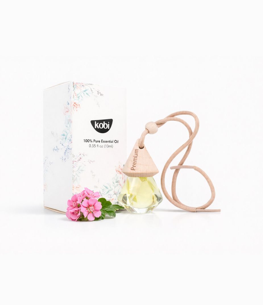 Tinh dầu treo xe ô tô Phong Lữ Kobi với hộp trắng, chai treo gỗ và hoa phong lữ hồng trên nền sáng sạch