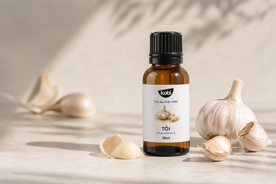 Tinh dầu tỏi trong bố cục tổng quan với củ tỏi tươi và chai thủy tinh nâu