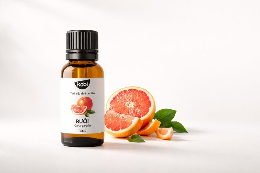 Tinh dầu bưởi Kobi chai thủy tinh nâu trong khung cảnh sáng sạch, mang tinh thần bài viết tổng quan