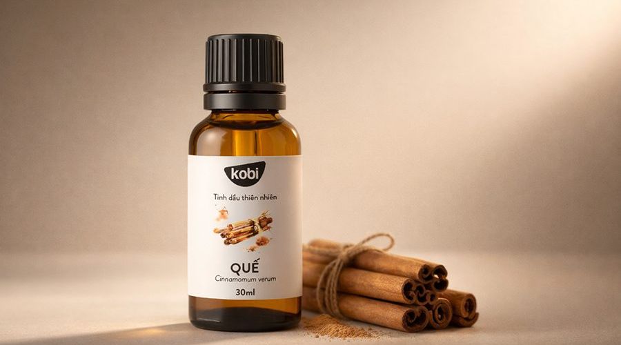 Tinh dầu quế Kobi trong không gian ấm với quế thanh và ánh sáng nhẹ