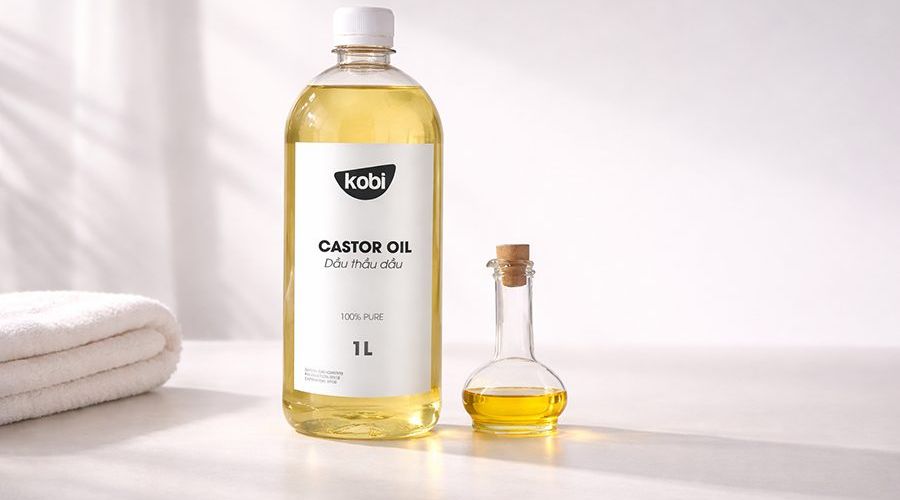 Công dụng của dầu thầu dầu trong chăm sóc cá nhân với chai dầu đặt trên nền sạch tối giản