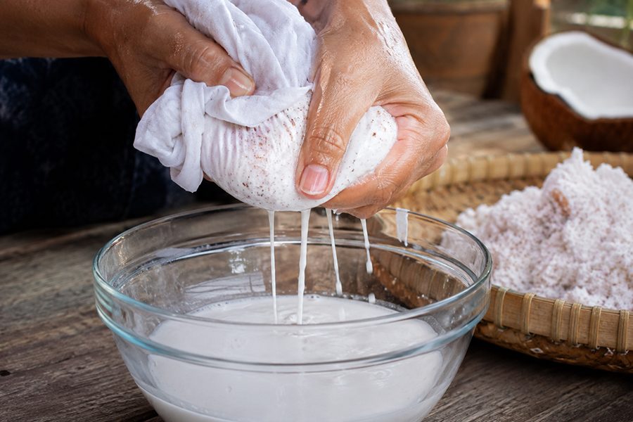 Lọc nước cốt dừa bằng vải sạch trong gian bếp gia đình